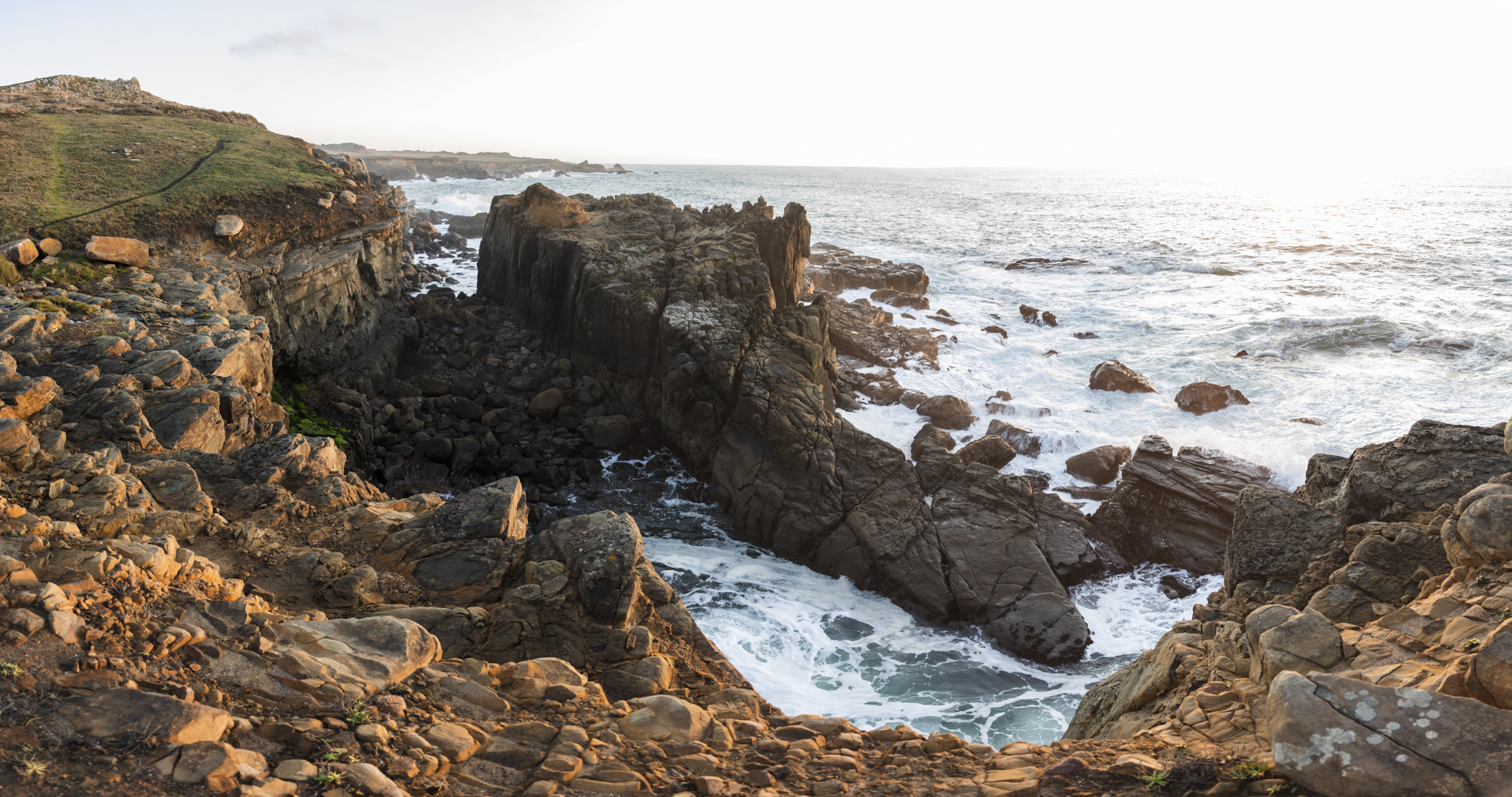 Landscape photo of sandstone cliffs in the breaking surf of the Sonoma Coast at sunset