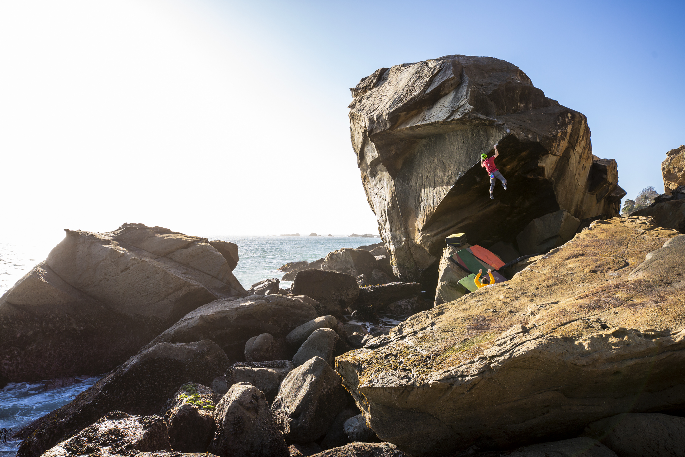 Action photo of pro climber Kevin Jorgeson sending a highball boulder problem on the Sonoma Coast in California.